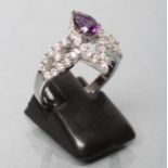 AN AMETHYST AND DIAMOND COCKTAIL RING, the tear cut amethyst claw set to an open border of point set