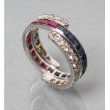 A DIAMOND, RUBY AND SAPPHIRE ETERNITY RING, the central band channel set with sapphires and rubies