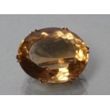 A LATE VICTORIAN CITRINE BROOCH, the oval facet cut stone claw set to a plain frame, stamped 9ct (