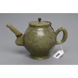 AN INDIAN CARVED AND POLISHED GREEN STONE TEAPOT of globular form with loop handle, the cover with