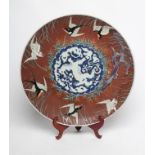 A JAPANESE PORCELAIN CHARGER of plain circular form, centrally painted in underglaze blue with a