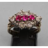 A RUBY AND DIAMOND CLUSTER RING, the three central small rubies point set to a lozenge panel with