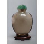 A CHINESE SMOKY CRYSTAL SNUFF BOTTLE, well hollowed out, 2 3/8" high, with domed jade(?) stopper and