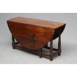 AN OAK DROP LEAF TABLE, early 18th century, the oval plank top on arched frieze and ring and