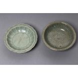 A CHINESE CELADON GLAZED SMALL DISH of lobed circular form, centrally carved with a flower spray,