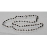 A BLACK DIAMOND BEAD NECKLACE, the facet cut stones peg set to plain unmarked links (Est. plus 21%