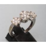 A DIAMOND TRIPLE CLUSTER RING, the central seven stone cluster point set and flanked by a pair of