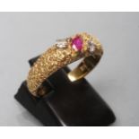 A MODERNIST 18CT GOLD RING, the brushed bark effect shank centred by a marquise cut ruby flanked