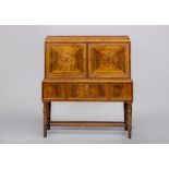 A ROSEWOOD DRINKS CABINET, first half 20th century, of oblong form with stringing, the stepped top