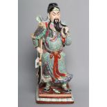 A CHINESE PORCELAIN FIGURE modelled as a celestial warrior wearing brightly coloured robes holding a