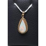 AN OPAL PENDANT, the tear polished opal in rub over setting with rope twist border on a plain