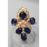 A SAPPHIRE AND DIAMOND DRESS RING, the six oval facet cut sapphires claw set with small diamond pave