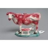 A STAFFORDSHIRE POTTERY COW CREAMER, c.1830, modelled with a calf, with pink sponged markings,