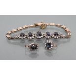 A SAPPHIRE BRACELET, the five graduated stones within cubic zirconia borders set to shaped links,