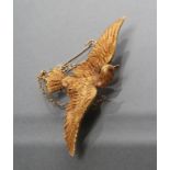 A LATE VICTORIAN DOVE IN FLIGHT BROOCH with chased feathers and ruby eyes, stamped 15ct (Est. plus