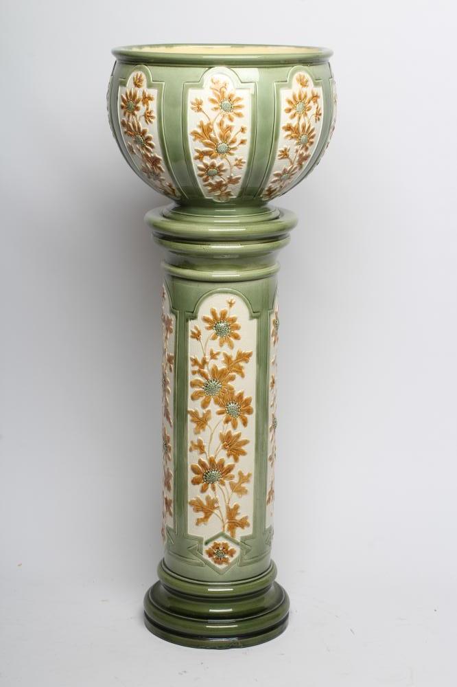 A BURMANTOFTS FAIENCE JARDINIERE AND STAND, early 20th century, moulded with panels of flowers