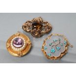 THREE VICTORIAN BROOCHES comprising a boss centred by an amethyst coloured cabochon within coral
