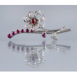 A RUBY AND DIAMOND SPRAY BROOCH, the single flower with ruby centre and pave set diamond petals
