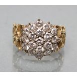 A DIAMOND CLUSTER RING, the nineteen brilliant cut stones point set to modernist 18ct gold open