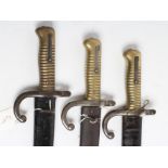 THREE M1866 FRENCH BAYONETS, all with back blade inscriptions, brass hilts and steel scabbards,
