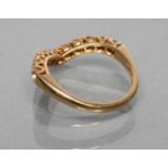 A WISHBONE RING to match the previous lot set with eleven stones to a plain 18ct gold shank,