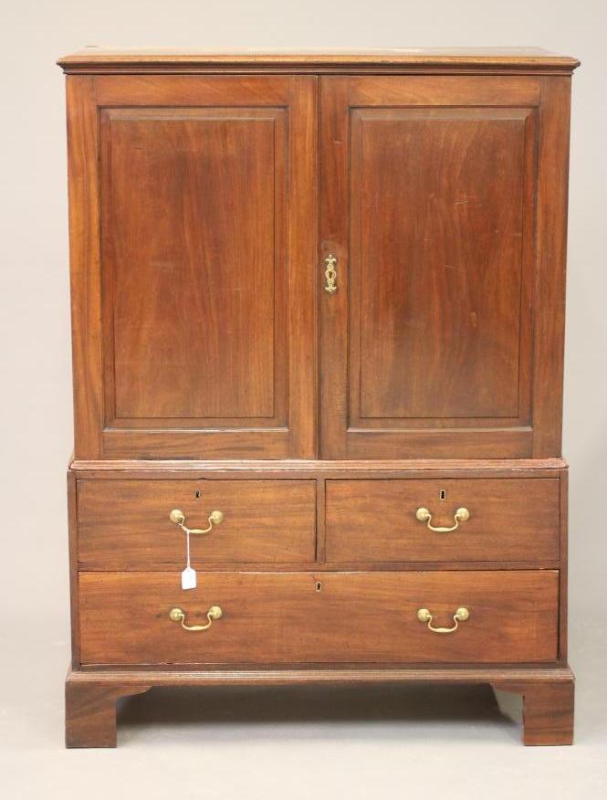 A MAHOGANY LINEN PRESS, late 18th century and later, the moulded cornice over two fielded panel