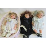 Three Lee Middleton Reva dolls, all with open blue eyes, largest 22" long, together with a wicker