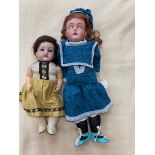 Two bisque socket head dolls, comprising a 14" doll with blue glass fixed eyes