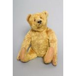 An early Steiff teddy bear, with orange plush, button eyes, sewn nose, felt pads, long arms, back