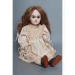 A Tete Jumeau bisque socket head doll, with brown glass fixed eyes, closed mouth, pierced ears,