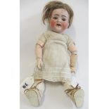 A Kammer & Reinhardt bisque socket head doll, with brown glass eyes, open mouth, teeth, brown wig,