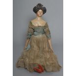 A papier mache doll, c.1830, shoulder head with moulded hair and painted features, shaped and