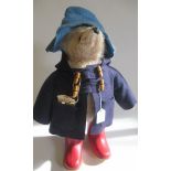 A Paddington Bear, with amber eyes, blue felt hat and coat, red Dunlop wellies and original label,