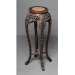 A CHINESE HARDWOOD JARDINIERE STAND, c.1900, the beaded edge circular top with veined red marble