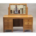 A ROBERT THOMPSON ADZED OAK DRESSING TABLE, the bevelled oblong swing mirror on turned faceted