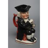 AN ENOCH WOOD TYPE EARTHENWARE DRUNKEN PARSON OR DR. JOHNSON TOBY JUG, c.1800, wearing a black