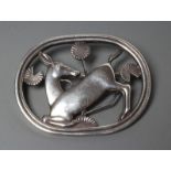 A GEORG JENSEN SILVER OVAL BROOCH designed by Arno Malinowski, cast as a kneeling deer, stamped