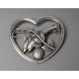 A GEORG JENSEN SILVER HEART BROOCH designed by Arno Malinowski, cast as two dolphins swimming amidst