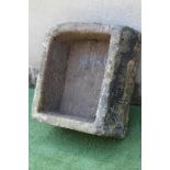 A SANDSTONE TROUGH of rough hewn deep oblong form with one rounded corner, 28 1/4" x 24" x 13" (Est.
