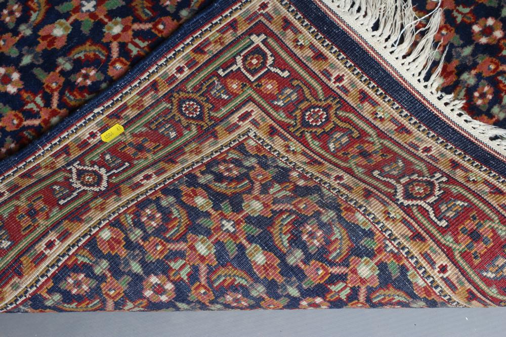 A PERSIAN RUG, the navy blue field with repeating pattern of foliate scrolls and flower heads, the - Image 3 of 3