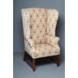 A GEORGIAN DESIGN MAHOGANY AND ELM FRAMED WING ARMCHAIR, 19th century, upholstered in a cream and