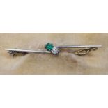 AN EMERALD AND DIAMOND BAR BROOCH, the circular facet cut stones claw set to an asymetrical knife