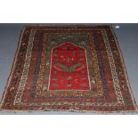 A TURKISH PRAYER RUG, the green field with stepped red niche with flowers and candles, within a