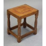 A ROBERT THOMPSON ADZED OAK STOOL of oblong form with padded cow hide seat, on faceted turned and