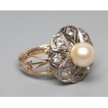 A PEARL AND DIAMOND COCKTAIL RING, the peg set cultured pearl within a white metal petal border