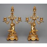 A PAIR OF FRENCH GILT METAL THREE LIGHT FIGURAL CANDELABRA inset with onyx panels, early 20th