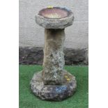 A SANDSTONE BIRD BATH, the rough hewn octagonal bowl raised on square tapering stem and octagonal