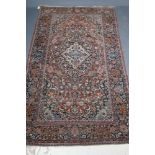 A PERSIAN RUG, the red floral field with navy blue and ivory gul, the navy blue main border with