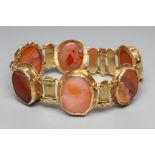 A BRACELET, the six oval polished banded agate panels in rub-over settings with bar links between,