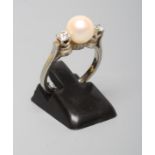 A THREE STONE PEARL AND DIAMOND DRESS RING, the cultured pearl of approximately fourteen metric